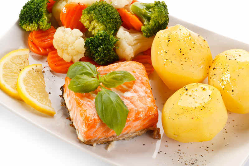 Plate of grilled salmon, potatoes and vegetables